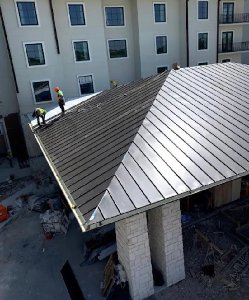 Crew installing standing seam metal roof panels on a commercial project in Sunnyvale